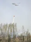 ROBERT DeBERRY/Frontiersman A state Division of Forestry
helicopter drops water on a brush fire off Knik-Goose Bay Road on
Carmel Road Friday afternoon.