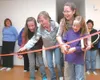 ROBERT DeBERRY/Frontiersman From left, Cathy, Becky, Beth and
Sarah Winter cut the ribbon on their new Habitat for Humanity home
in Palmer Saturday afternoon.