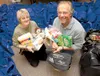 Family Promise Mat-Su Executive Director Laurie Kari and Dave
Rose of Mat-Su Coalition on Housing and Homelessness hold an armful
of necessities that will be handed out at Project Homeless Co