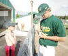 ROBERT DeBERRY/Frontiersman Mat-Su Miner Michael Carlson signs a
ball for Palmer resident Hunter Mill during the meet the Miners
night at Hermon Brothers Field Friday evening.
