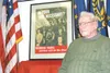 Homer Thacker, a World War II veteran who moved to the Valley in
2003, sits next to a poster from that war that asks people to
curtail unneccesary travel. Thacker is featured on the poster,
w