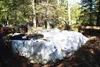 A tarp covers some drums of fuel oil Friday afternoon at a site along Ruth Drive in Wasilla. Neighbors say the property containing the drums is an unlicensed dump. Property owner Gene Brooks 