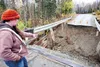 Debra Castro points to where the Shirley Towne Bridge fell into Willow Creek during last week's flooding. The bridge is the only way to access the homes on the north side of Willow Creek. ROB