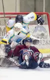 ROBERT DeBERRY/Frontiersman Fairbanks forward Jon Waggoner
slides into Alaska Avalanche goalie Landon Peterson and defenseman
Jake Williams during the first round of North American Hockey
Lea