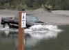 A truck crosses Bodenburg Creek near a sign directing four-wheelers and other vehicles to proper vehicle crossing areas in the salmon habitat protected creek. ROBERT DeBERRY/2011 file Frontie
