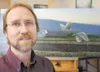 ROBERT DeBERRY/Frontiersman Valley artist Shane Lamb sits in his
Palmer studio in front of a recently finished piece that will be
auctioned off by the Monroe Foundation in Fairbanks. The piec