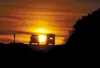 Vehicle traffic traveling along Knik-Goose Bay Road is silhouetted against the setting sun Monday afternoon. The state plans to expand the road from its current two lanes to four, and in some