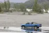ROBERT DeBERRY/Frontiersman A vehicle drives up Bodenburg Creek
near the Knik River Thursday afternoon. Bodenburg Creek is a salmon
stream, meaning it is illegal to drive in, but it is legal 