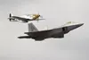 A vintage P-51 Mustang flies alongside a U.S. Air Force F-22 Raptor during a heritage flight for the Arctic Thunder Special Needs and Family Day at Joint Base Elmendorf-Richardson, Alaska dur