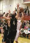 Wasilla senior Cash McGregor tries to put a shot over the reach of Colony's Damien Fulp (4) and Robert Sonnenberg (22) during a loss to the Knights Tuesday at Wasilla High. Photographer: Bruc