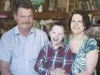 Willie Koonce, 8, laughs as he sits for a photograph with
parents Joel and Carmi inside their Meadow Lakes home Saturday
afternoon. The family is holding a series of fund-raisers to help
pay 