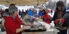 Sarah Clausan, of EmJays Mobile Foods, prepares food for a customer during the Iditarod Restart Sunday in Willow. Jacob Mann/Frontiersman