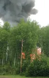 Smoke billows above the treeline as flames become visible through the trees at a house fire in the Willow area Monday morning. Courtesy Debbie Cardwell