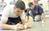 ROBERT DeBERRY/FrontiersmanPalmer Job Corp student Michael
Phillips attempts to balance an egg on end as Jomel Dizon looks on.
Phillips and Dizon are part of a group of students that balanced