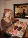 Kaitlyn Powell, front of house staff at Dead Horse Donuts, shows off a typical assortment of donuts available at the shop. Mark Kelsey/For the Frontiersman