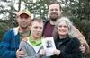 From left are Nathan Hvamstad, son Austin, wife Leslie and Leslie’s son Chevi Perry. Leslie and Austin are holding a celebration of life flyer for Leslie’s daughter, Danielle Rose Adams McMor