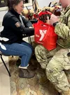 A volunteer with the Armed Services YMCA of Alaska assists a service member during the organization’s recent Thanksgiving outreach. Photo courtesy of Armed Services YMCA of Alaska