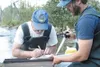 Alaska Department of Fish and Game biologists Jim Novak and Sam
Ivey install a radio transmitter in a rainbow trout Thursday
morning on Montana Creek. The transmitters, about as big as a
pers
