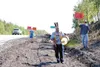 Knik Tribal Chief Paul Theodore drums while others hold signs on
a hill in Wasilla, off Knik-Goose Bay Road. The group is protesting
dirtwork being done on the hill in preparation for widenin