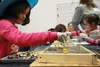 First-grader Annabella Burley puts the finishing touches on her and her partner's mosaic, which will soon become a link in the outline of a labyrinth to be installed outside Shaw Elementary S
