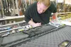 ROBERT DeBERRY/Frontiersman file photo Chimo Guns sales
associate Craig Pell checks the serial number on an AR-15 assault
style rifle. Pell says he enjoys watching customers gaze longingly
at