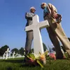 World War II Distinguished Service Cross recipients James "Maggie" Megellas (left) of Colleyville, Texas, and Roy Hanna of Southern Pines, N.C., share a private moment at the grave of friend 
