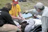 Lou Holzeneck of Mat Su Search and Rescue, center, checks on Kaitlyn Eggleton during a simulated wilderness emergency response led by the North American Outdoor Institute’s teen wilderness ch
