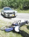 ROBERT DeBERRY/Frontiersman A motorcycle ridden by Randal Smith,
21, lays on the shoulder of the Seward-Meridian Parkway after
colliding with a Wasilla Police Department vehicle driven by
Off
