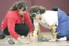 (ROBERT DeBERRY/Frontiersman) Camp Ability coach Jenna Stricken
helps Kelsy Tallant, 12, feel the tape on the floor before starting
a game of goalball Friday durng the Camp Abilities summer c