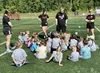 J.B. Schwartz, standing, second from right, addresses his charges at the start of a Little Warriors Soccer Academy session on June 11 at the Wasilla High School field. Schwartz, who is head g