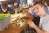 Cutter Tormey smirks at the camera while working on a friendship bracelet at the YAK, the new youth center open to middle and high school students in downtown Palmer. CAITLIN SKVORC/Frontiers