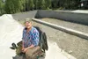 ROBERT DeBERRY/Frontiersman Jim White sits in front of the
foundation for his new home Monday afternoon.