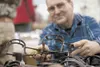 Andrew ‘Art’ Drabeck Jr. holds one of his 100-year-old traps Saturday at the Palmer Lions Club Gun Show at Raven Hall on the Alaska State Fairgrounds in Palmer. Robert DeBerry