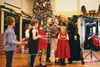 Local singer/songwriter Adele Morgan hands the microphone to her younger "back-up" singers during one of many Christmas carols sung at the 2014 Jack White Real Estate Christmas party at the V