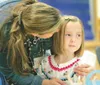 ROBERT DeBERRY/Frontiersman Machetanz Elementary School
first-grade teacher Molly Walker welcomes Keegan Hansen, 6, to the
first day of school Monday morning.