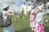 Sarah Hughes takes a photograph of her daughter and two nieces
at the Children's Garden Fair Tea Party Saturday afternoon in
Palmer. (ROBERT DeBERRY/Frontiersman)