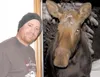 Brad Howe poses with a moose that showed up on his deck and
poked its head into the doorway of his Valley home. According to
Howe, the moose had been around earlier in the day, but had left.
