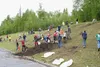 CASEY RESSLER/Frontiersman Fifth-graders take topsoil from the
bottom of the hill beside Finger Lake Elementary School and use it
to fill in around the apple trees they planted last week.