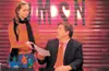 Andy Dwyer, geography and media skills teacher at Wasilla Middle School, accepts copy from reporter and eighth-grader Shyanne Massie during the first episode of WMSN, the student-produced mor