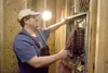 ROBERT DEBERRY/Frontiersman Alcan Electric’s Brandon Warner
pulls wire in the new concession stand at Hermon Brothers Field on
Saturday. Warner is one of a number of people who have donated
t