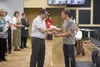 Mat-Su Borough School Board member Erick Cordero (left) hands a hammer to Devan Cherneski in recognition of Cherneski’s work as part of the team of students that built a brand-new school boar