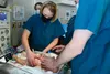 U.S. Air Force Col. Kirsten Aguilar, left, Joint Base Elmendorf-Richardson and 673d Air Base Wing commander, performs chest compressions while U.S. Air Force Chief Master Sgt. Lee Mills, JBER
