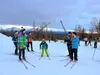 Volunteer ski instructors stand at a finish line during a relay at the final Wednesday session of the Mat-Su Ski Club's Junior Nordics ski season in March, 2022.  Amy Bushatz/For the Frontier