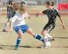 ROBERT DeBERRY/Frontiersman Palmer junior Shea Riggs, left,
takes the ball from Juneau’s Marlena Sloss during the first half of
Thursday’s game at Palmer High School’s Machetanz Field.