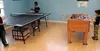 Attendees of the Day Habilitation Center grand opening play a game of ping pong and test the foosball table in the game room. The activity center also offers areas for computer use, relaxatio