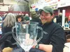 Jake Berkowitz poses with the large glass loving cup he won in recognition of the care he gave his dogs during this year’s Iditarod Trail Sled Dog Race. This was Berkowitz’s third finish and 