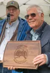 Mike Mosesian, foreground, was honored as 2025 Farm Family of the Year by Bryan Scoresby, Director of the Division of Agriculture, on August 15 at the Alaska State Fair. Mosesian and his fami