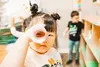 A child peeks through a scope made from a piece of paper at Meadow Lakes Head Start Center in 2023. Photo by Lela Sieler through CCS Early Learning