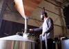 Jake Wade, head brewer at Bear Paw River Brewing Company, demonstrates how he and his brother-co-workers are able to adjust the amount of grain sifted into the boiling pot in the brewing proc