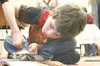 John Paul Culbertson, 9, really gets into cutting out images in
a magazine to add to his collage. Culbertson and other children who
attend Sutton Elementary School have been working on collag